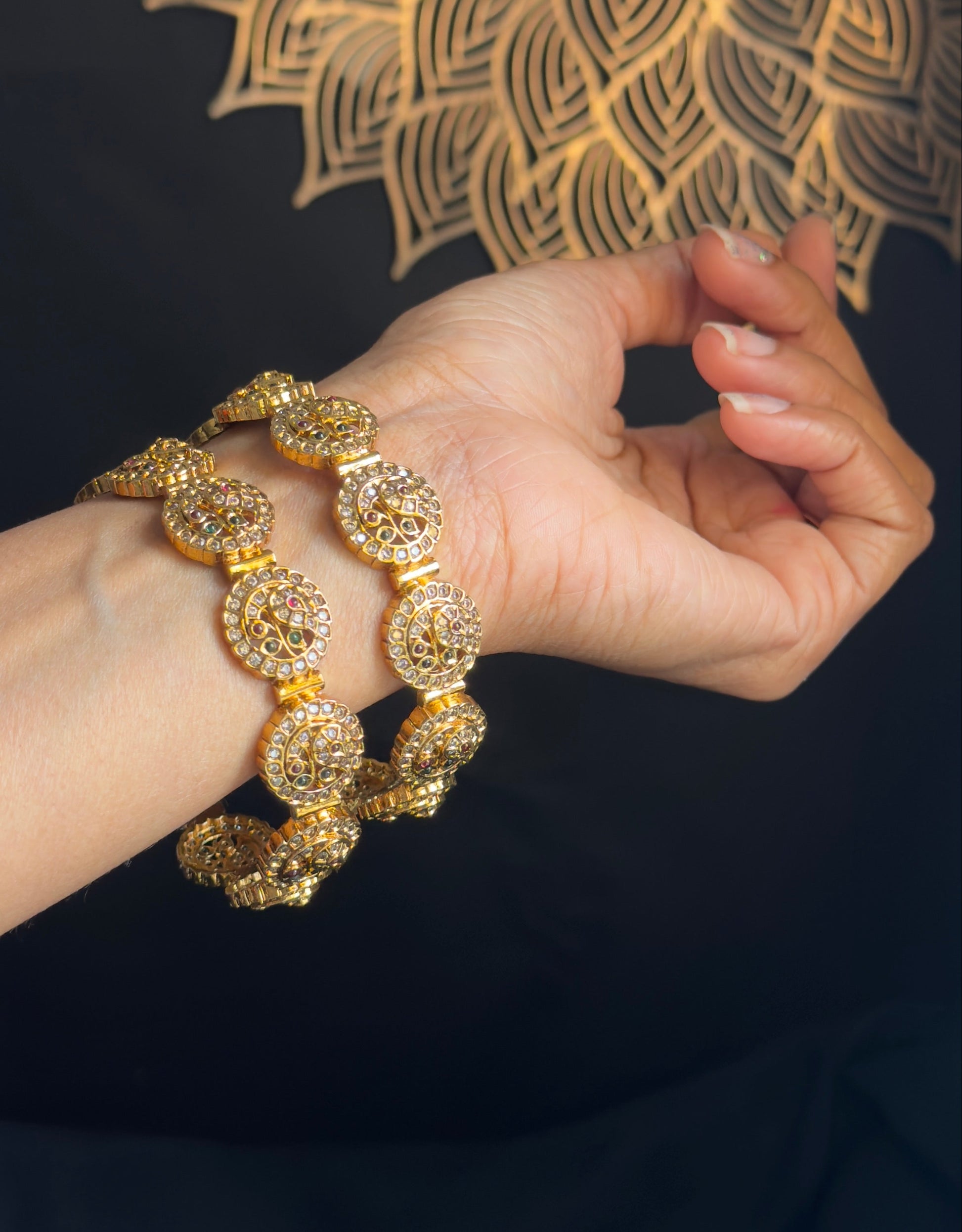 Gold bracelet on a hand with a decorative gold background