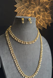 Gold necklace and earrings on a mannequin bust with a decorative gold background.