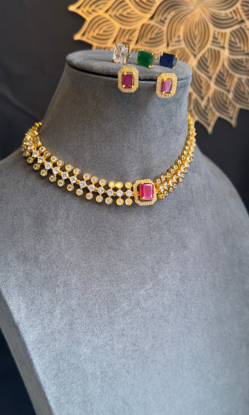Gold necklace with colorful gemstones on a mannequin bust with matching earrings.