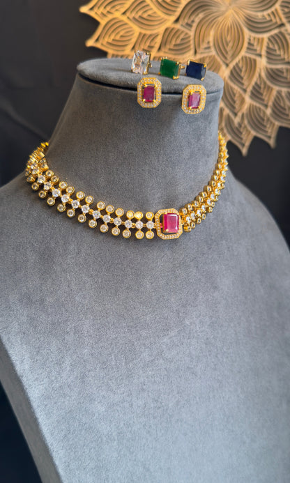 Gold necklace with colorful gemstones on a mannequin bust with matching earrings.
