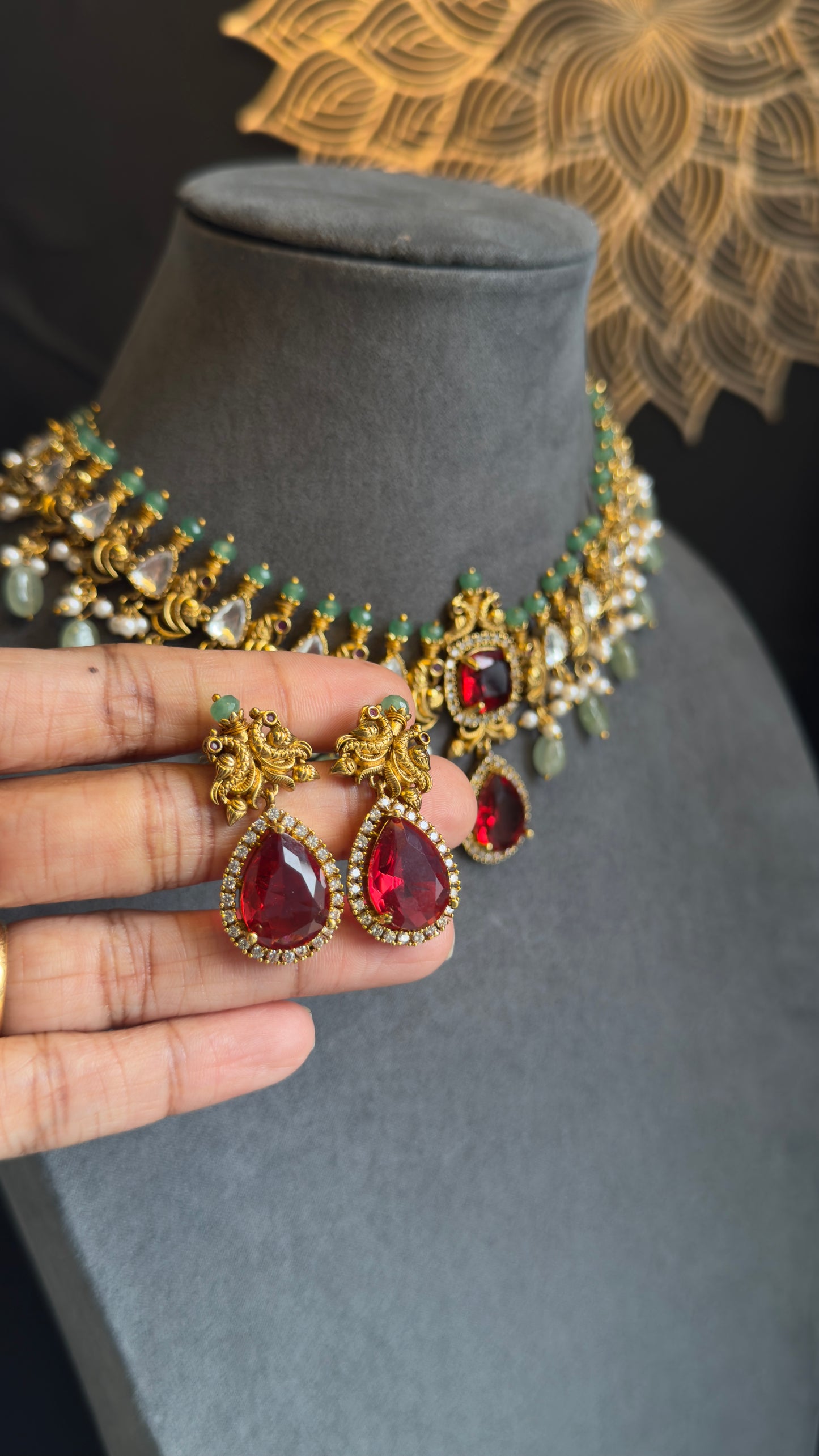 Jewelry set with red gemstones on a mannequin and hand
