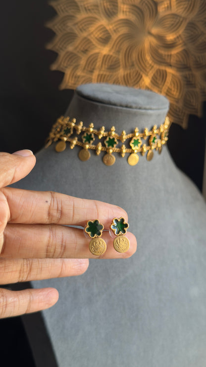 Gold jewelry set with green stones on a mannequin and hand