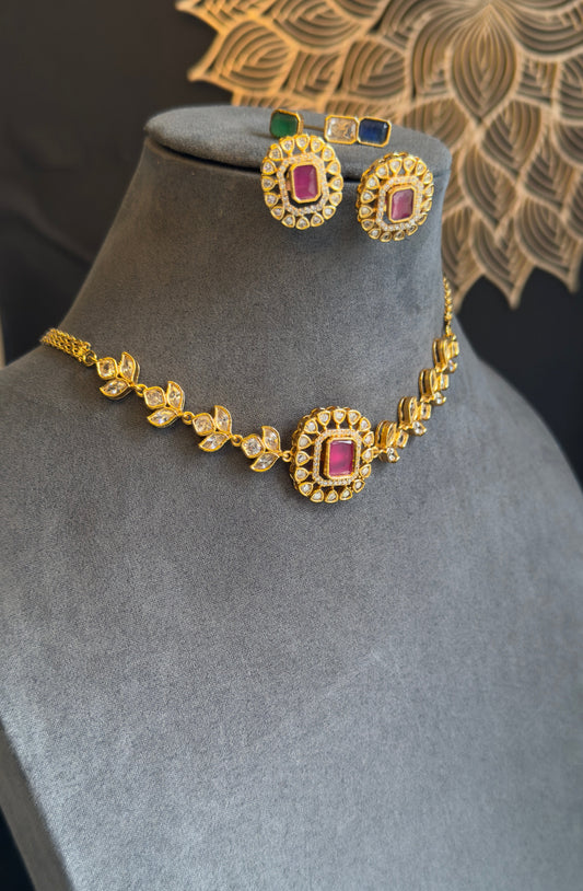Gold necklace with red gemstones on a gray mannequin bust