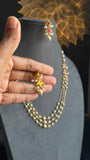 Hand holding a pearl necklace with a decorative background