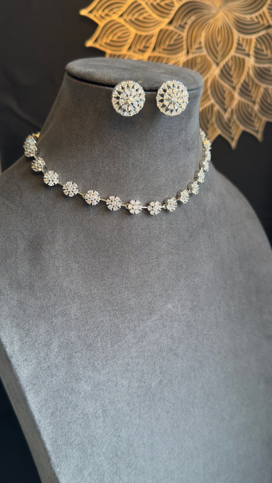 Jewelry set with necklace and earrings on a gray mannequin bust.