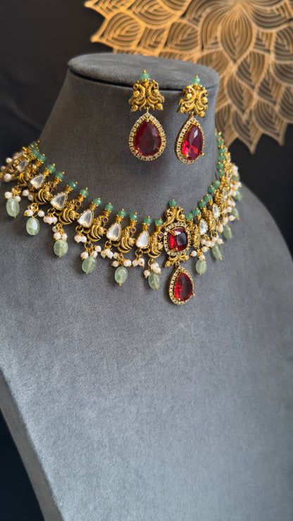 Ornate necklace and earrings set on a mannequin bust with a decorative background